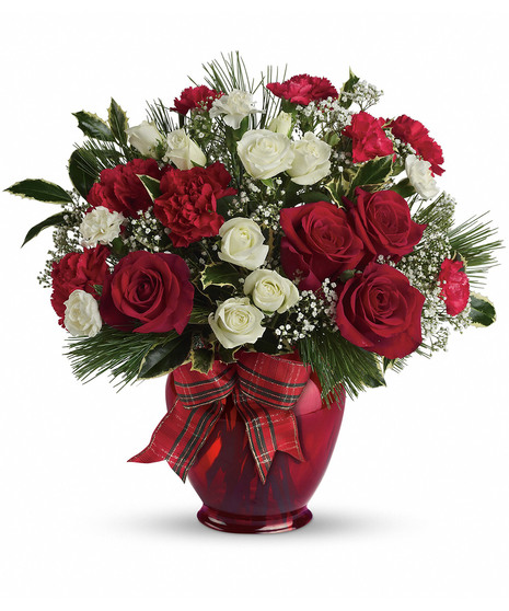 A bouquet of red and white flowers arranged in a red vase, adorned with green leaves and a plaid ribbon, placed against a plain white background.