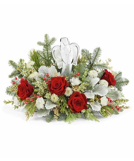 A festive arrangement of red roses, pinecones, and lush greenery sits in a red vase adorned with a cardinal bird design, complemented by white flowers and red berry accents.